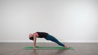 Yoga teacher performing yoga posture on green yoga mat on white background