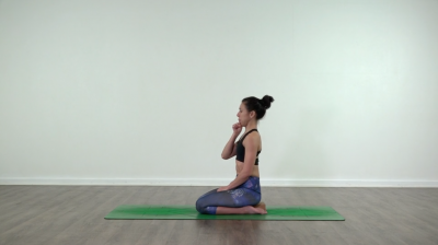 Lizette is practising yoga on a green yoga mat