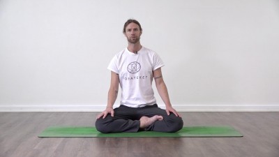 Yoga teacher performing yoga posture on green yoga mat on white background