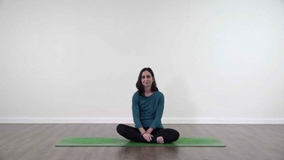 Yoga teacher performing yoga posture on green yoga mat on white background