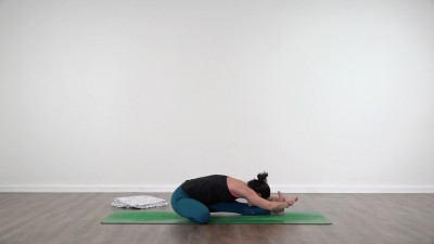 Yoga teacher performing yoga posture on green yoga mat on white background