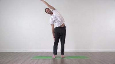 Yoga teacher performing yoga posture on green yoga mat on white background
